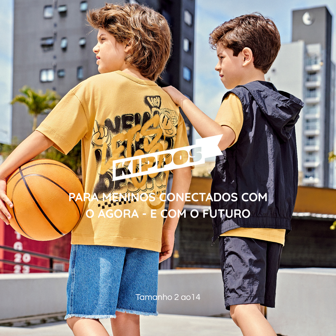 Dois meninos usando roupas urbanas da Kippos em um cenário de cidade, com camiseta oversized, bermuda jeans e conjunto esportivo. Um deles segura uma bola de basquete. Moda infantil para meninos dos tamanhos 2 ao 14.