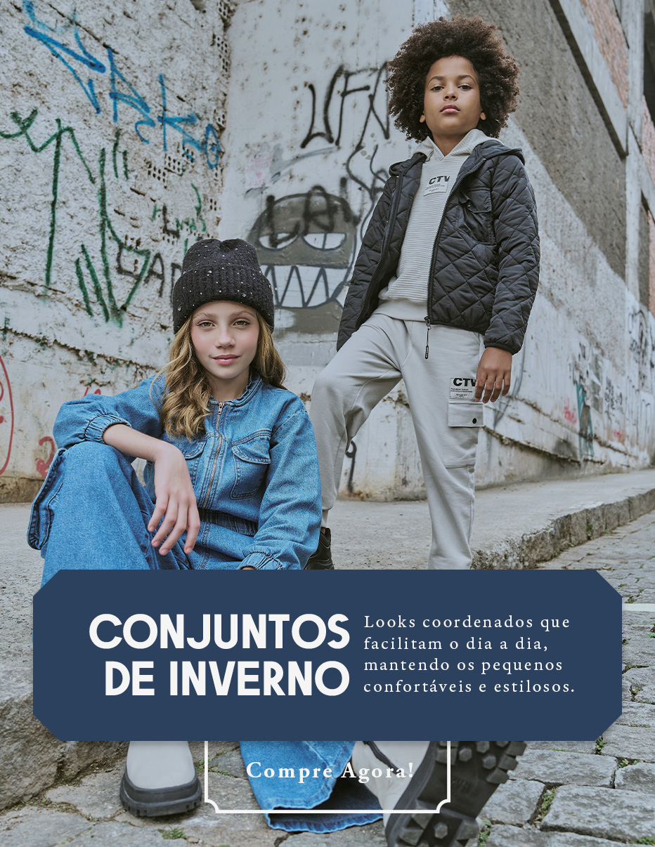 Criança vestindo conjunto jeans e outra criança com conjunto esportivo cinza e jaqueta preta posam em uma rua com grafites, representando moda infantil de inverno com estilo urbano.